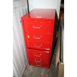 A SMALL RED METAL FILING CABINET