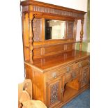 AN EDWARDIAN CARVED OAK MIRRORBACKED SIDEBOARD