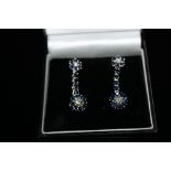 A PAIR OF SAPPHIRE & DIAMOND EARRINGS, each set with a small cluster of sapphires surrounding a cen