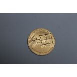 A YELLOW METAL COIN/TOKEN, one side with a building and written uttinburra 764 ottobeuren 1964 and