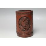 A CARVED CHINESE BAMBOO BRUSH POT, detailed with a Phoenix oval vignette and a similar to the rever