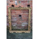 AN EARLY 18TH CENTURY CARVED GILTWOOD FRAME, of rectangular outline, with scrolling rococco detail,