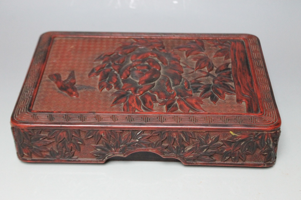 A CHINESE CINNABAR LAQUER BOX, decorated with a bird flying around a flower with floral detail to