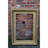 A 19TH CENTURY GILTWOOD PICTURE FRAME, of rectangular outline, decorated with fruit and vine moulde