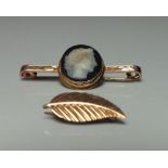 A HALLMARKED 9CT GOLD BAR BROOCH WITH CAMEO PANEL, L 3.8 cm, together with a yellow metal delicate