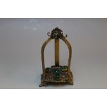 AN UNUSUAL GILT METAL JEWELLED STAND, french in style and set with a variety of pretty coloured cab
