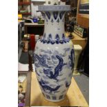 A LARGE ORIENTAL STYLE BLUE & WHITE CERAMIC VASE WITH DRAGON DETAIL