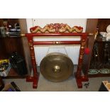 A LARGE CHINESE BRASS GONG AND BEATER ON CARVED PAINTED WOODEN STAND WITH TWO DRAGON FINIAL