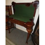 AN IRISH MAHOGANY FOLD OVER GAMES TABLE WITH BAIZE TO THE INTERIOR, RAISED ON TAPERED SUPPORTS AND
