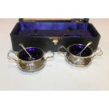 A CASED PAIR OF ANTIQUE SILVER CONDIMENT SERVERS AND CONDIMENT SPOONS