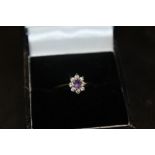 A 9CT GOLD FLORAL SET AMETHYST RING