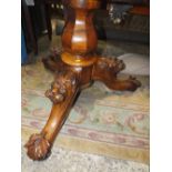 A 19TH CENTURY WALNUT CIRCULAR DINING TABLE WITH UNUSUAL CARVED BASE WITH DOG HEAD MASKS, Dia. 138