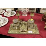 AN ANTIQUE INK STAND FITTED WITH TWO CUT GLASS BOTTLES TOGETHER WITH A BRASS BLOTTER AND A PAIR OF