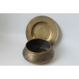 AN ISLAMIC BRASS BOWL WITH SILVER AND COPPER DECORATION, along with an Oriental cast brass plate -