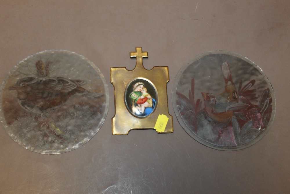 TWO CIRCULAR GLASS PANELS PAINTED WITH BIRDS PLUS A SMALL RELIGIOUS PORTRAIT IN METAL FRAME