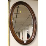 AN OVAL FRAMED MIRROR