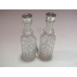 A PAIR OF CUT GLASS AND HALLMARKED SILVER CASTERS