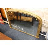 A GILT FRAMED ARCHED OVERMANTEL MIRROR A/F