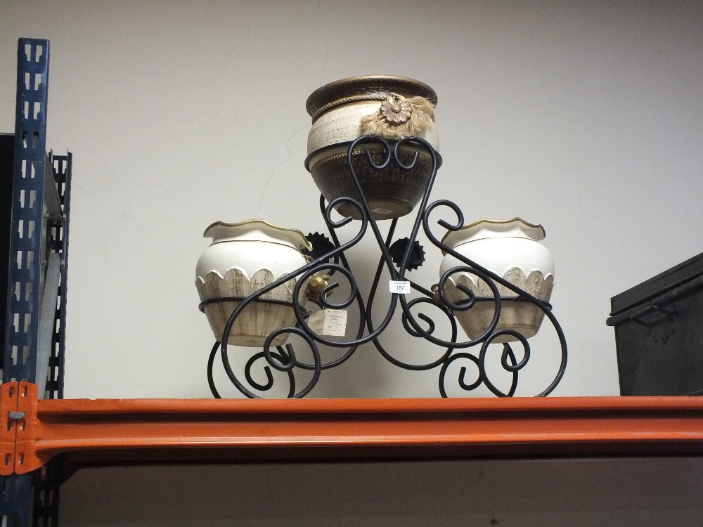 THREE CERAMIC PLANTERS ON A CAST METAL STAND