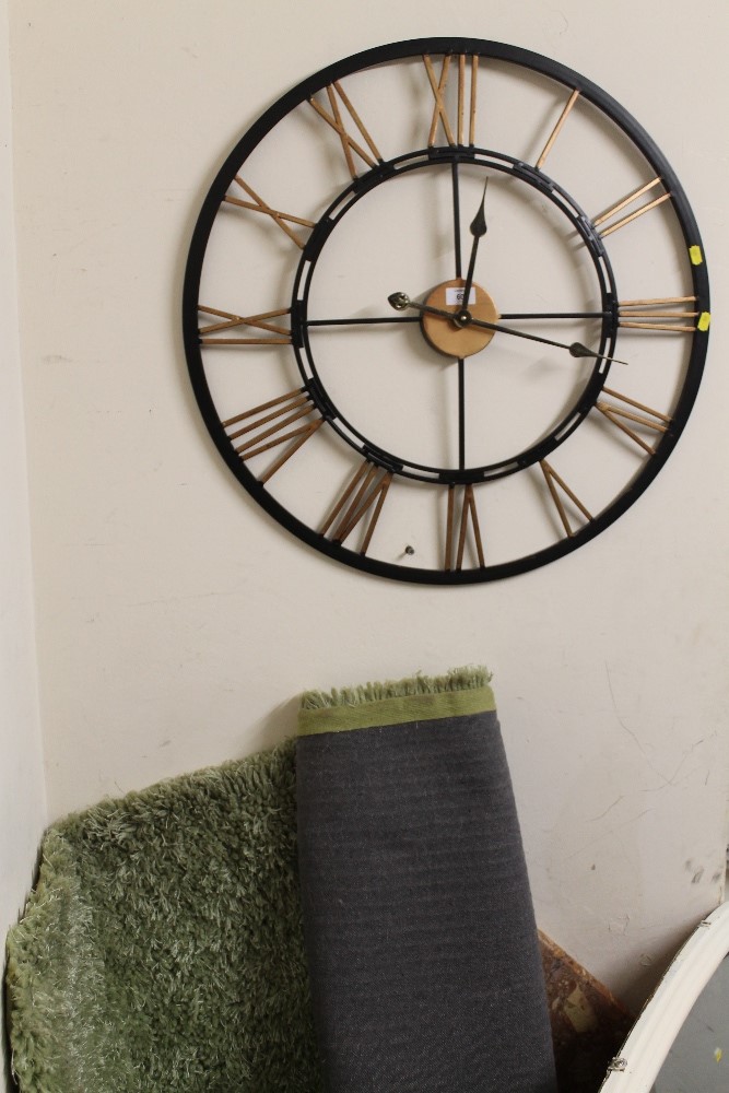 A MODERN OPEN WALLCLOCK AND A GREEN RUG (2)