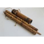 TWO DAYAK BLOW PIPES, with incised and coloured decoration, with a collection of darts in a carry t