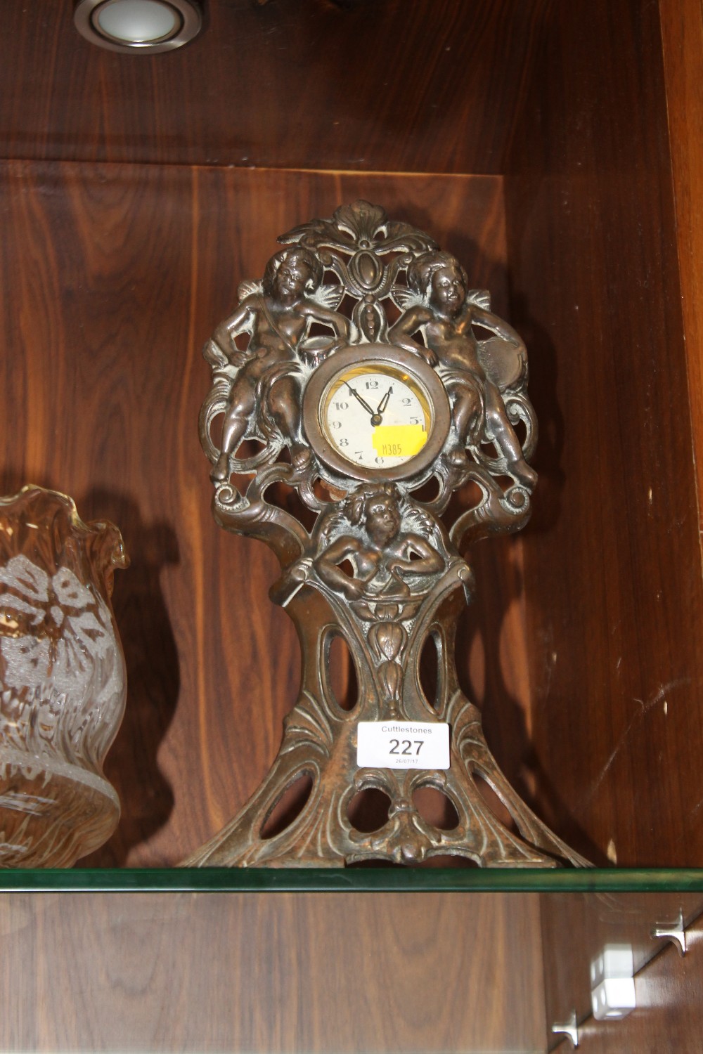 AN ART NOUVEAU CAST METAL MANTEL CLOCK WITH CHERUBIC FINIALS