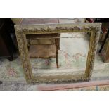 A LARGE ANTIQUE GILT PICTURE FRAME WITH ACORN DECORATION