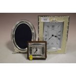A 925 SILVER FRAMED DESK CLOCK TOGETHER WITH ANOTHER CLOCK AND A WHITE METAL PICTURE FRAME
