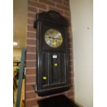 AN OAK CASED EDWARDIAN WALLCLOCK