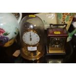 A GLASS DOMED KUNDO MANTLE CLOCK TOGETHER WITH A CARRIAGE CLOCK