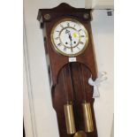 A WALL HANGING CLOCK WITH WEIGHTS AND PENDULUM