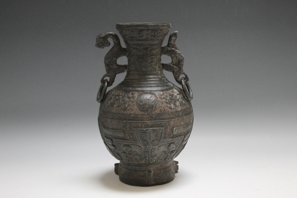 A BRONZE ARCHAISTIC TYPE HU VASE, having ornate swirl detailing and twin handles, H 21.5 cm