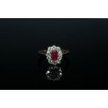 AN 18 CARAT GOLD RUBY AND DIAMOND RING, the central emerald cut ruby being of approx 0.75 carat is