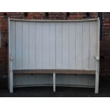 A LARGE AND UNUSUAL LATE 19TH CENTURY CURVED BACK SETTLE, the panelled painted back and sides above