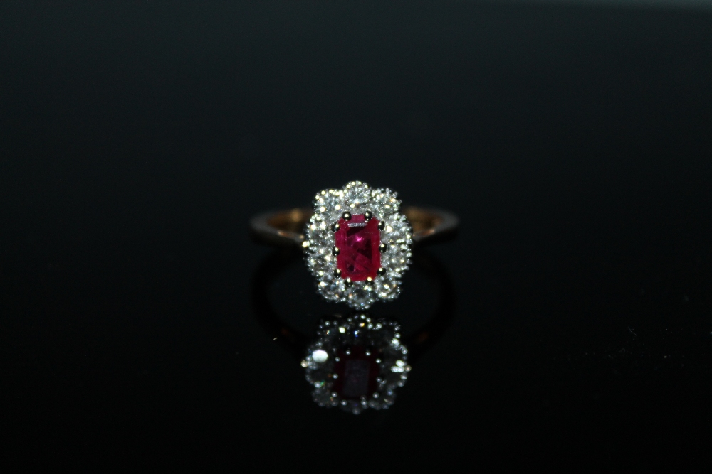 AN 18 CARAT GOLD RUBY AND DIAMOND RING, the central emerald cut ruby being of approx 0.75 carat is - Image 2 of 2