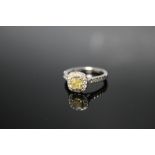 A HALLMARKED PRINCESS CUT YELLOW DIAMOND PLATINUM RING, the central claw set yellow diamond is of g