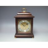 AN ASPREY & GARRARD WALNUT CASED MANTEL CLOCK, brass dial with silvered chapter ring, cherubic mask