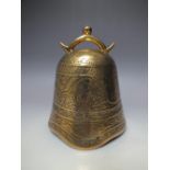 A 20TH CENTURY TIBETAN BRASS TEMPLE BELL OF TYPICAL FORM, having all over decoration with central b