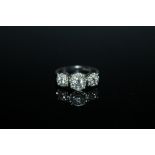 A HALLMARKED 18 CARAT WHITE GOLD DIAMOND CLUSTER TRILOGY RING, set with brilliant cut diamonds of a