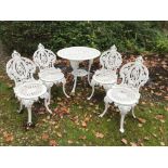 A HEAVY CAST WHITE PAINTED PATIO SET, circular table and four chairs, the table with mask head deco