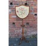 A PAINTED SATINWOOD POLE SCREEN, the glazed shield shaped screen with an inset floral silk panel, t