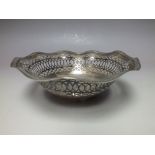 A HALLMARKED PIERCED SILVER BON BON DISH - SHEFFIELD 1912, of circular form, having wavy banded edg