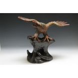 AN AMERICAN STYLE CARVING OF AN EAGLE, with wings outswept and standing upon a tree root base, H 52