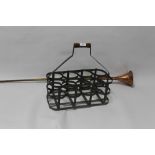 A VINTAGE BOTTLE HOLDER WITH WOODEN HANDLE TOGETHER WITH A BRASS AND COPPER POST HORN