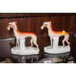 A PAIR OF STAFFORDSHIRE STYLE FIGURES OF GREYHOUNDS