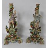 A PAIR OF DRESDEN STYLE STANDS decorated with a man and woman in typical floral dress