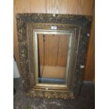 AN ANTIQUE GILT PICTURE FRAME WITH ACORN DETAIL