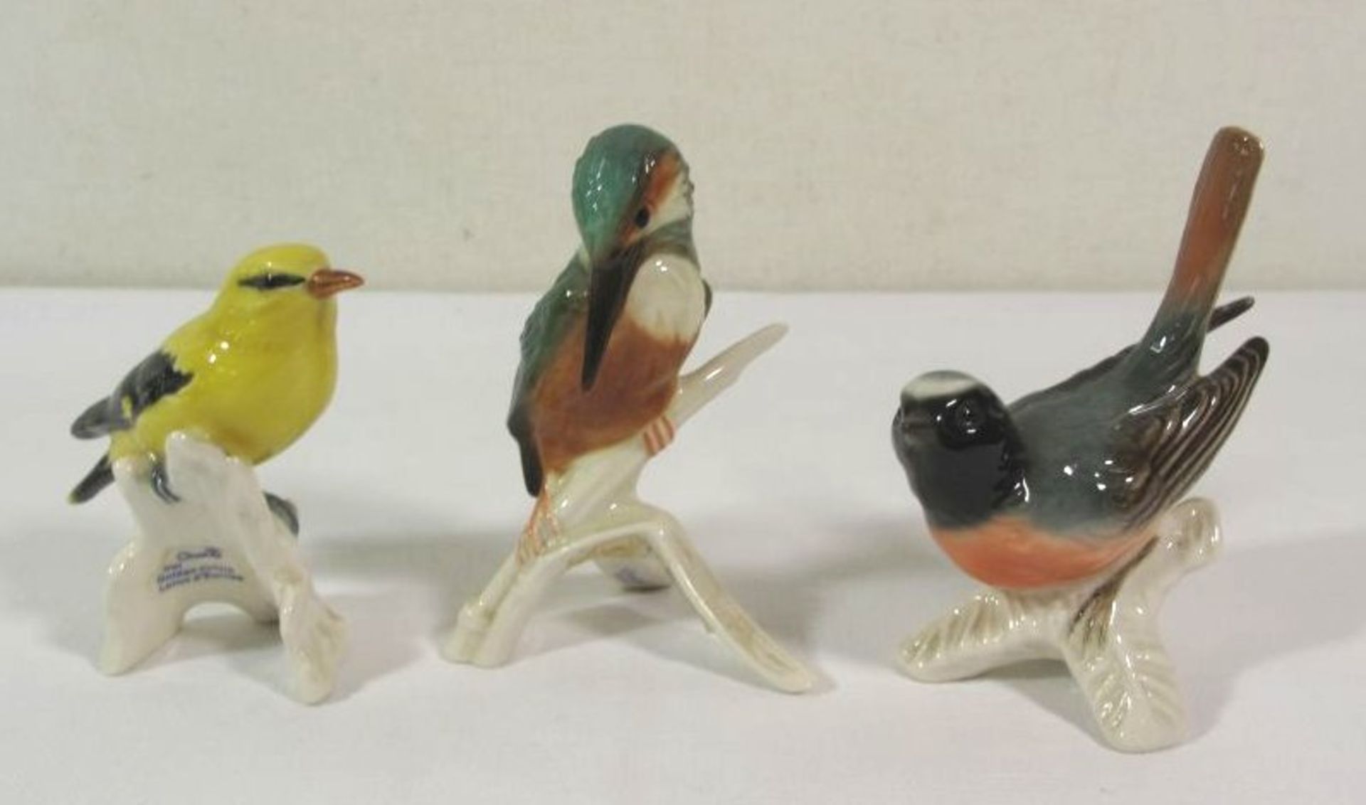 3x unterschiedl. Vogelfiguren "Goebel", polychr. Bemalung in Unterglasurfarben, ca. H-10cm.