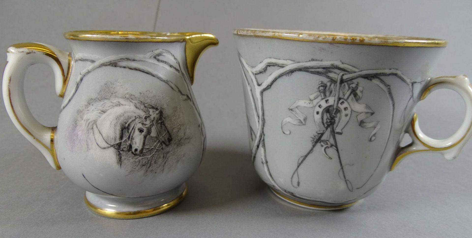 Tasse und Sahnekännchen, bemalt mit Pferdemotiven, dat. 1877, Golddekor tw. berieben, Kannenstand