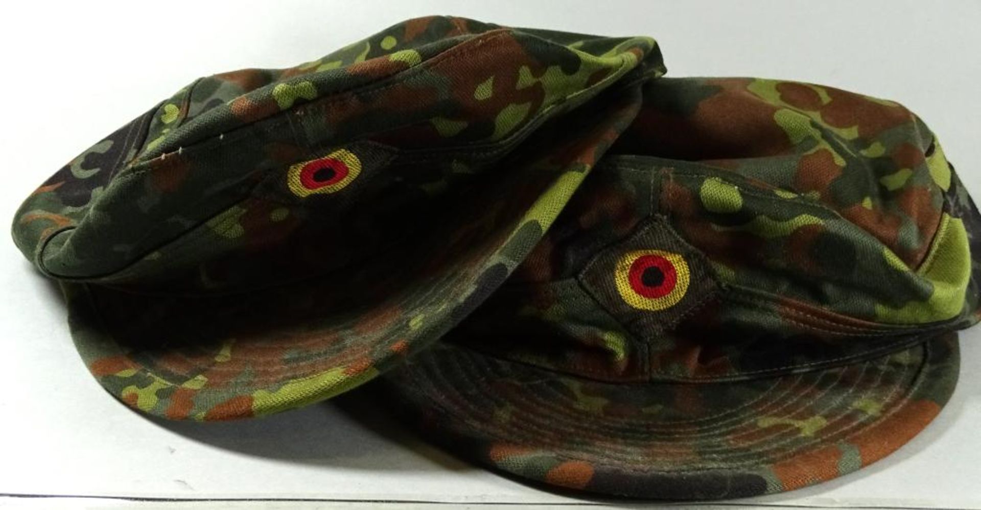 Zwei Kopfbedeckungen in Tarnfarben,1997, 59,